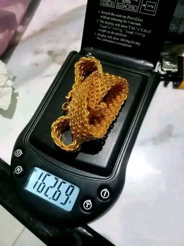 Kalung emas ditimbang dengan timbangan digital di hadapan pelanggan