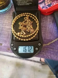 Kalung rantai emas di atas timbangan digital menunjukkan 16,72 gram